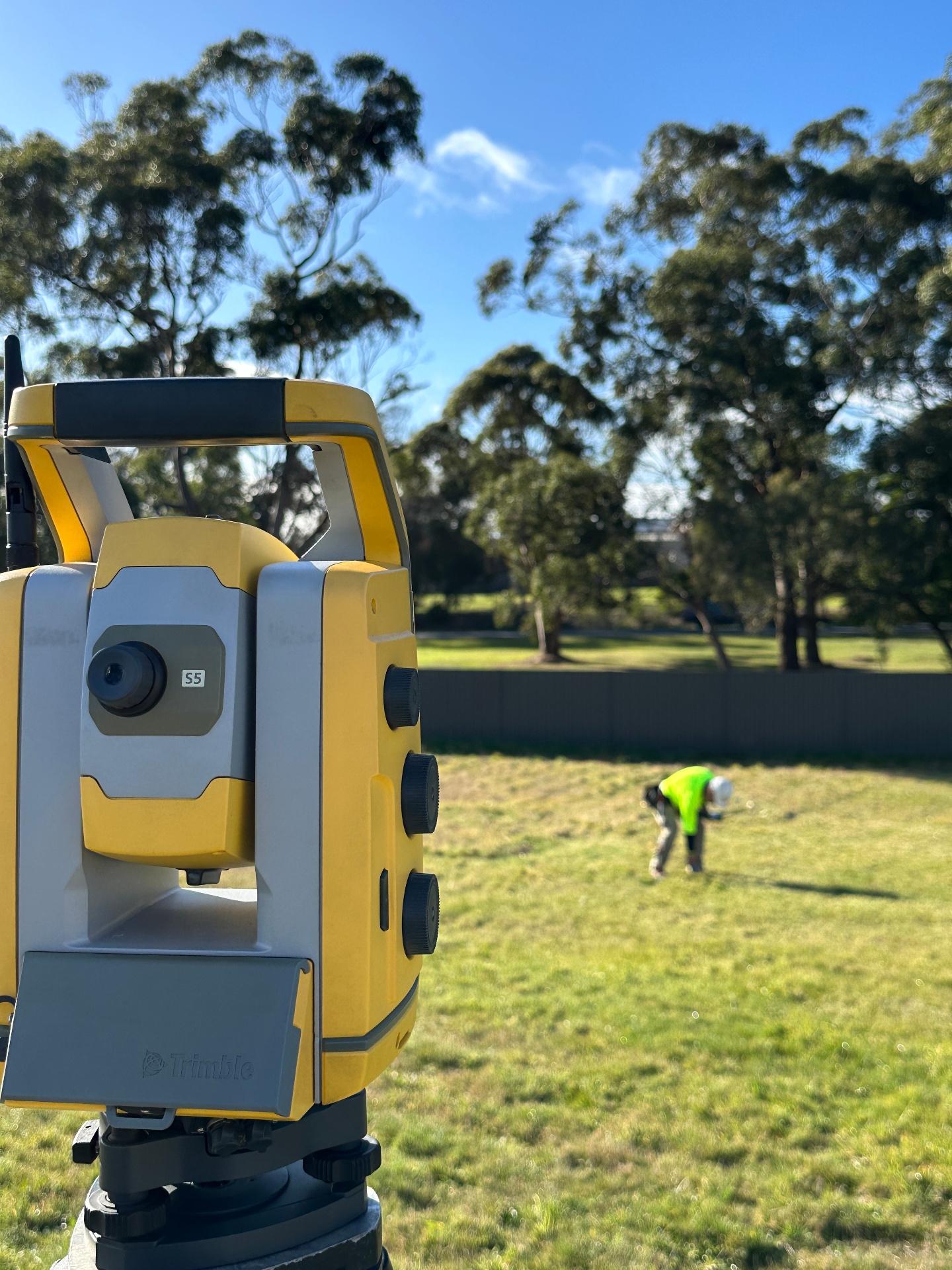 Advanced robotic total station with surveyor working in the background